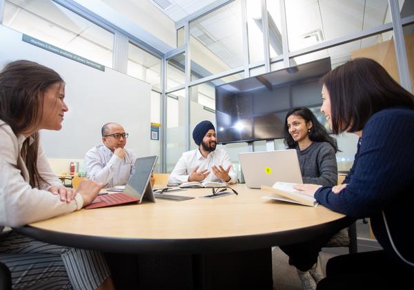 A group of 5 divers students around a table. 